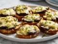 Chrupiące zapiekanki z airfryer z grzybami i ciągnącym serem, posypane ziołami. Idealna przekąska!