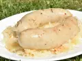 Dwie pyszne kiszki ziemniaczane na grilla, podane na talerzu z kapustą kiszoną. Idealne na letnie popołudnie.