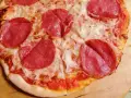 Pyszna pizza salami z serem i cebulą, idealna na szybki obiad.