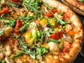 Pyszna pizza bez mięsa z brokułami, pomidorkami, kukurydzą, papryką i rukolą.