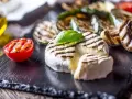 Pyszny camembert z grilla, z rumianymi paskami, podany z grillowanymi warzywami i pomidorkiem. Idealny na letnie wieczory.