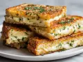 Złociste tosty z airfryer, z rozpływającym się serem i posypką z ziół. Idealne na szybką przekąskę.