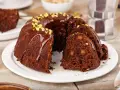 Wilgotna babka czekoladowa z orzechami, polana polewą i posypana pistacjami. Idealna na szybki deser.