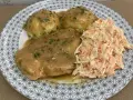 Pyszna pierś z kurczaka w sosie własnym, podana z ziemniakami i surówką z marchewki i kapusty.