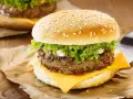 Zbliżenie na cheeseburgera z serem, sałatą i majonezem na bułce z sezamem.