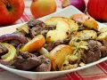 Pyszna wątróbka z jabłkiem, cebulą i grzybami na białym talerzu. Aromatyczne danie gotowe do podania.