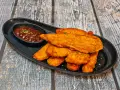 Chrupiący sznycel z kurczaka podany z sosem barbecue. Idealny na szybki posiłek.