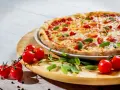 Apetyczna pizza z pomidorkami i bazylią. Czy zastanawiałeś się, dlaczego pizza jest niezdrowa?