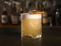 Klasyczny whisky sour przepis: orzeźwiający koktajl z pianką i plasterkiem suszonej pomarańczy. Idealny na każdą okazję.