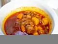 Zupa gulaszowa Ani gotuje się w głębokim talerzu. Mięso i ziemniaki w aromatycznym, czerwonym sosie.