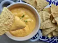 Chrupiące nachos zanurzane w kremowym sosie z serka topionego. Idealna przekąska na imprezę.