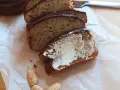 Pyszny chlebek bananowy z airfryera, pokrojony w kromki, jedna posmarowana masłem. Idealny na śniadanie.