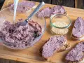 Pyszna pasta z czerwonej fasoli na chlebie, obok słoiczek sezamu. Idealna na szybką przekąskę.