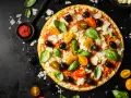 Pizza z pomidorkami, oliwkami i bazylią. Pomidorowe pesto to niezbędny dodatek smakowy włoskiej pizzy.