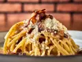 Pyszne włoskie dania z makaronem, jak Carbonara, z chrupiącym boczkiem i parmezanem.