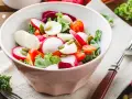 Świeża sałatka do grilla w 3 minuty: rzodkiewka, pomidorki, ser mozzarella i pestki dyni w misce.