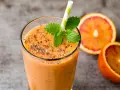 Pomarańczowy smoothie z nasionami chia i siemieniem lnianym, ozdobione miętą. Idealne na zdrowe śniadanie. Inspiracja na smoothie przepisy.