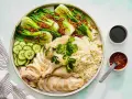 Pyszny kurczak hong kong z ryżem, pak choi, ogórkiem i sosami.