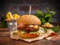Pyszny burger z serem, bekonem i sałatą, idealny jako dodatek do frytek.