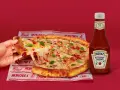 Ciepła pizza z ciągnącym serem i bazylią, obok butelka łagodnego ketchupu Heinz – idealny duet do każdego kęsa.