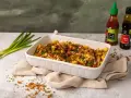 Pyszne frytki z chrupiącą posypką i sosem. Obok butelki sosu Sriracha i Tonkatsu, idealne do frytek.