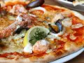 Wykwintna pizza z krewetkami, małżami i cytryną – być może najdroższa pizza na świecie, kusząca bogactwem owoców morza.