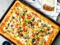 Pyszna pizza domowa na blachę z pieczarkami, papryką, oliwkami i pepperoni. Idealny przepis na szybki obiad.