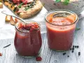 Dwa słoiczki Weck z domowymi dipami pomidorowymi, obok kawałek pizzy i miska makaronu. Idealne do pizzy i nie tylko!