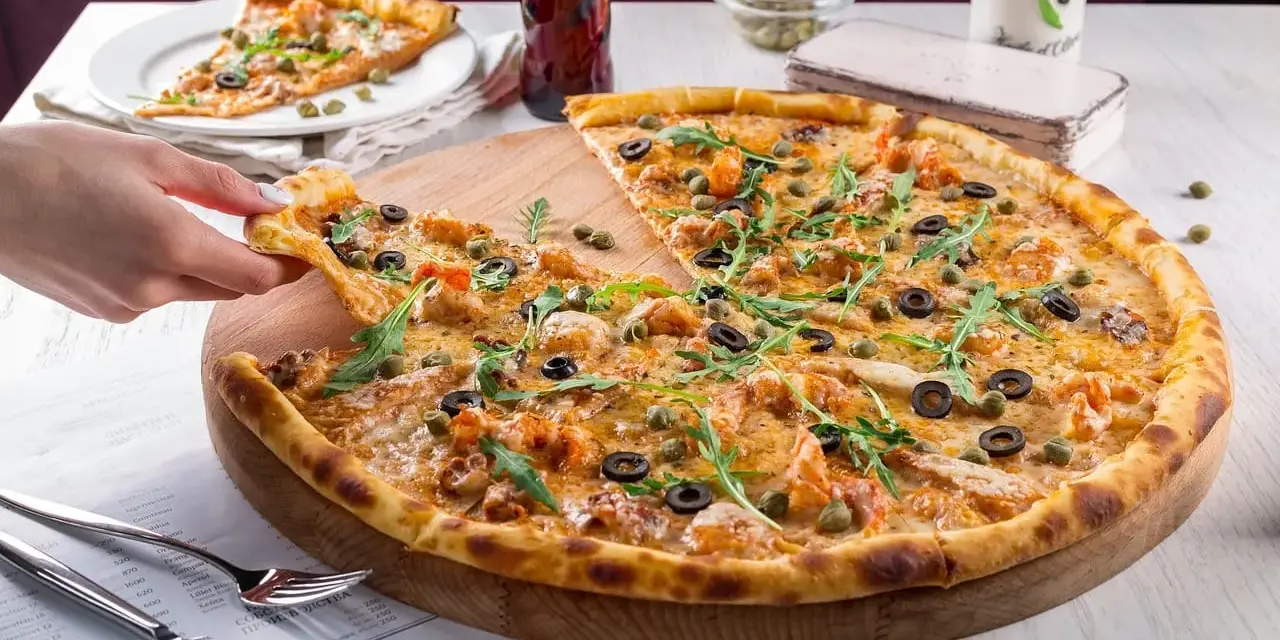 Pyszna pizza z krewetkami, oliwkami i kaparami, serwowana w klimatycznej **pizzerii Stare Miasto**. Idealna na wspólny posiłek.