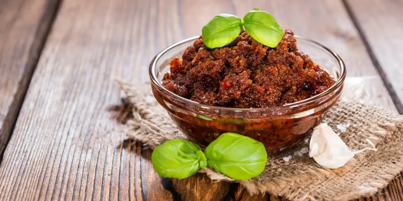 Miseczka pełna aromatycznego, czerwonego pesto z bazylią i czosnkiem, gotowa do podania.