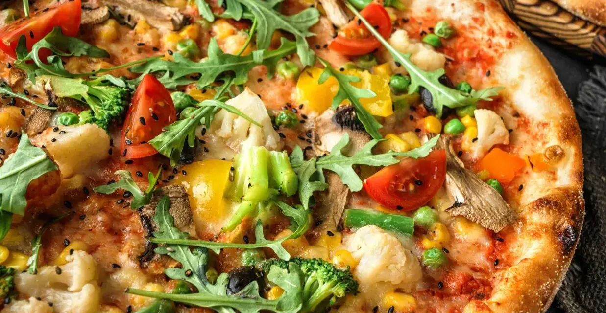 Pyszna pizza bez mięsa z brokułami, pomidorkami, kukurydzą, papryką i rukolą.