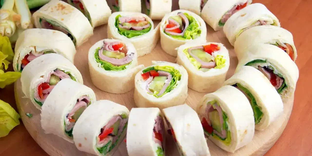 Szybkie przekąski z tortilli na zimno: roladki z szynką, serem, warzywami i sałatą. Idealne na imprezę lub lunch.