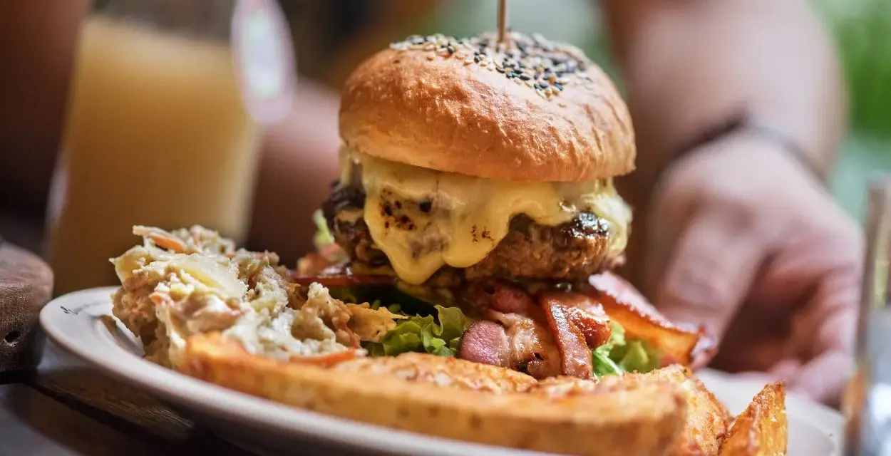 Pyszny burger drwala z rozpływającym się serem, chrupiącym boczkiem i surówką. Idealny na głód!