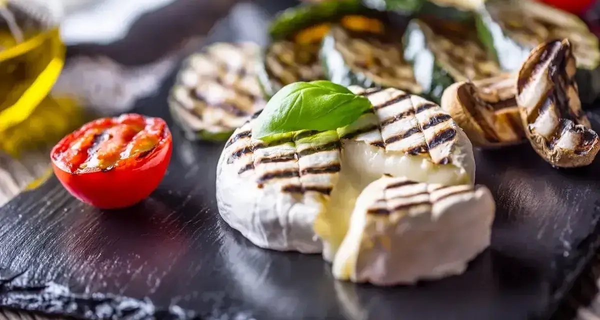 Pyszny camembert z grilla, z rumianymi paskami, podany z grillowanymi warzywami i pomidorkiem. Idealny na letnie wieczory.