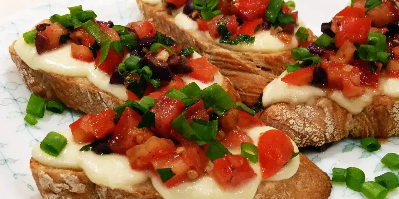 Bruschetta z pomidorami i mozzarellą: chrupiące pieczywo, roztopiony ser i świeże dodatki. Idealny przepis na szybką przekąskę.