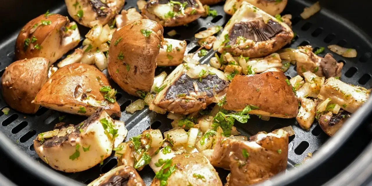 Pyszne pieczarki z airfryer, przyprawione i posypane natką pietruszki, gotowe do podania.