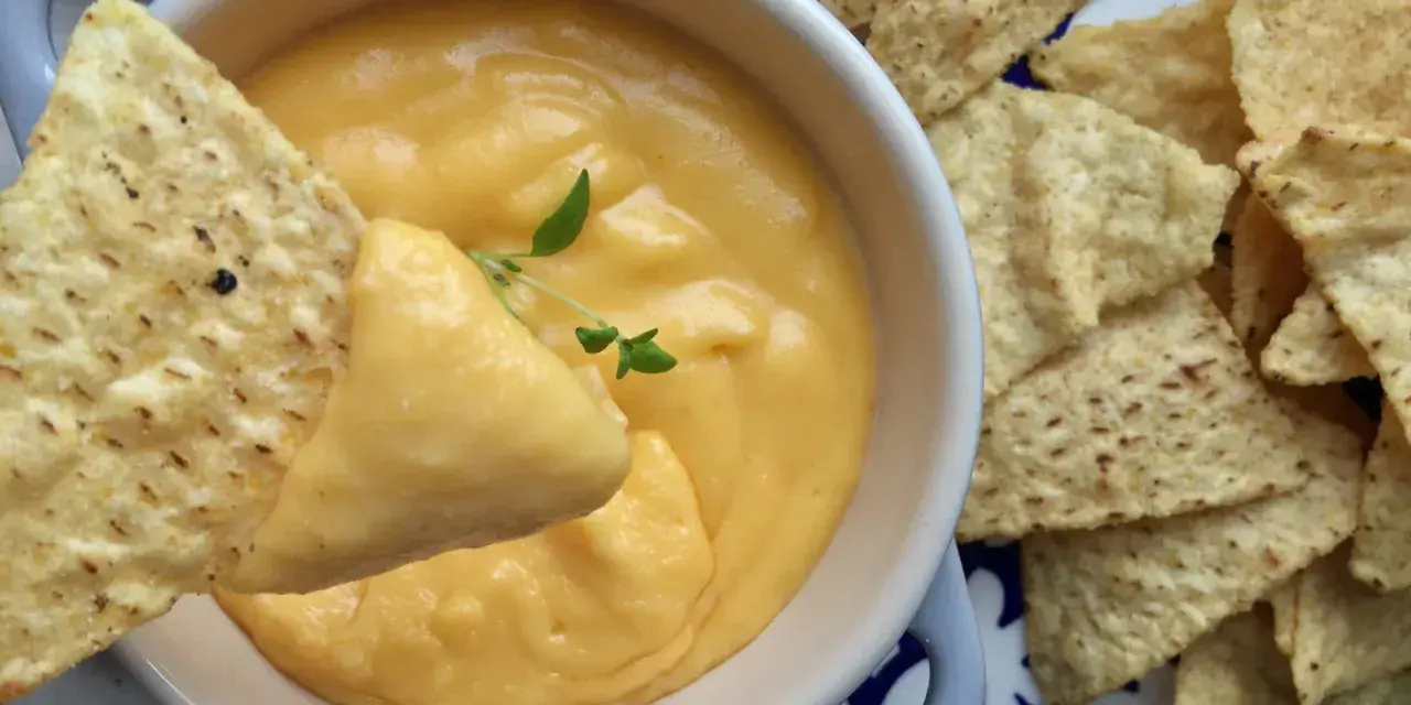 Chrupiące nachos zanurzane w kremowym sosie z serka topionego. Idealna przekąska na imprezę.