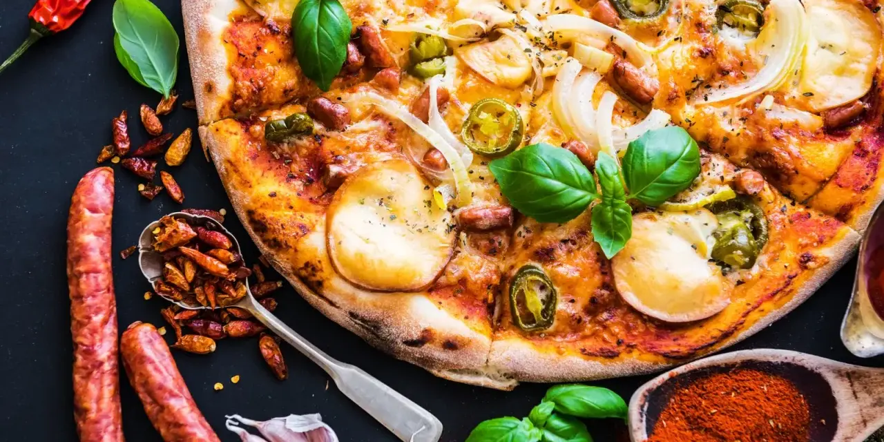 Apetyczna pizza z kiełbasą, cebulą i papryczkami jalapeño, otoczona składnikami.