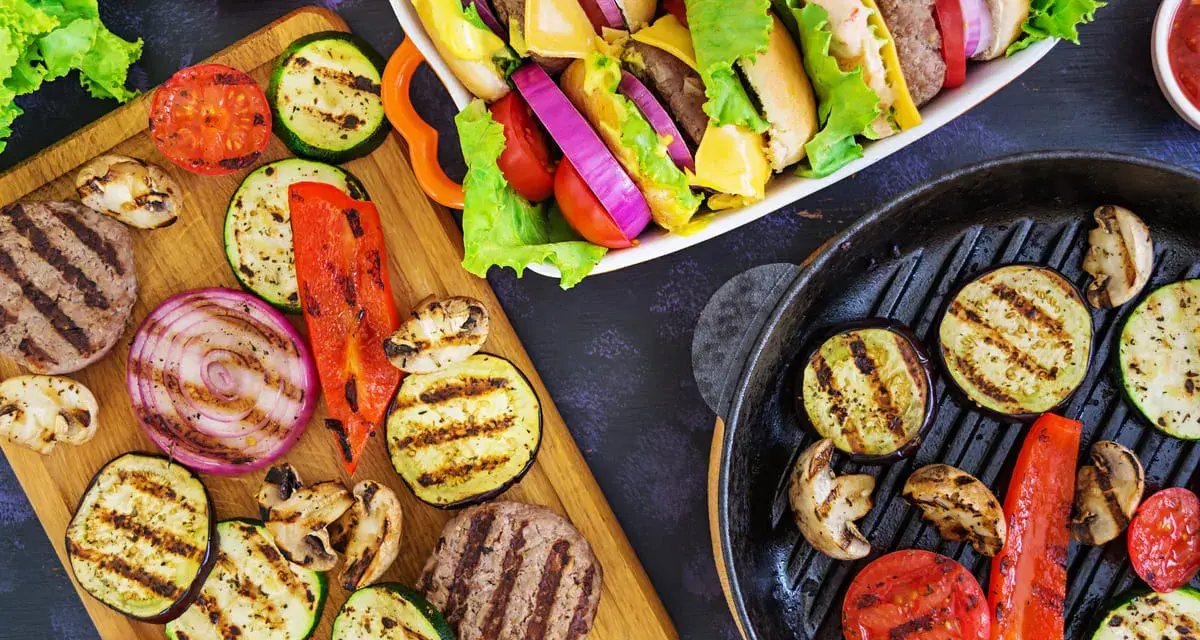 Pyszne przekąski na grilla: burgery, grillowane warzywa (cukinia, bakłażan, papryka, cebula, pomidory) i pieczarki. Idealne na letnie spotkania.