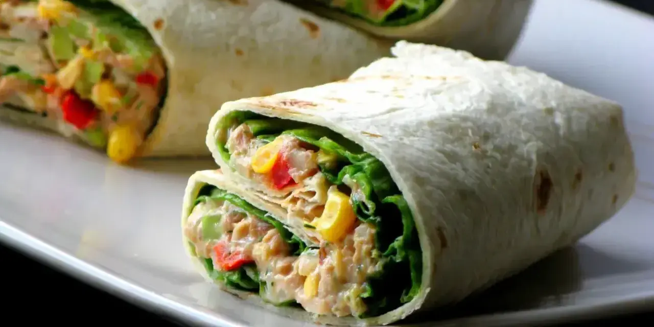 Pyszna tortilla z tuńczykiem, chrupiącą sałatą, kukurydzą i papryką. Idealna na szybki lunch.