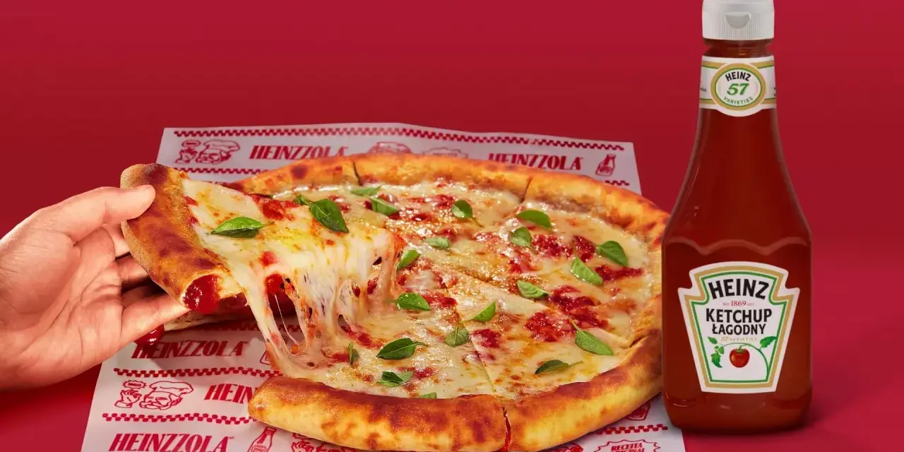 Ciepła pizza z ciągnącym serem i bazylią, obok butelka łagodnego ketchupu Heinz – idealny duet do każdego kęsa.