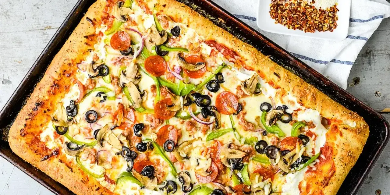 Pyszna pizza domowa na blachę z pieczarkami, papryką, oliwkami i pepperoni. Idealny przepis na szybki obiad.
