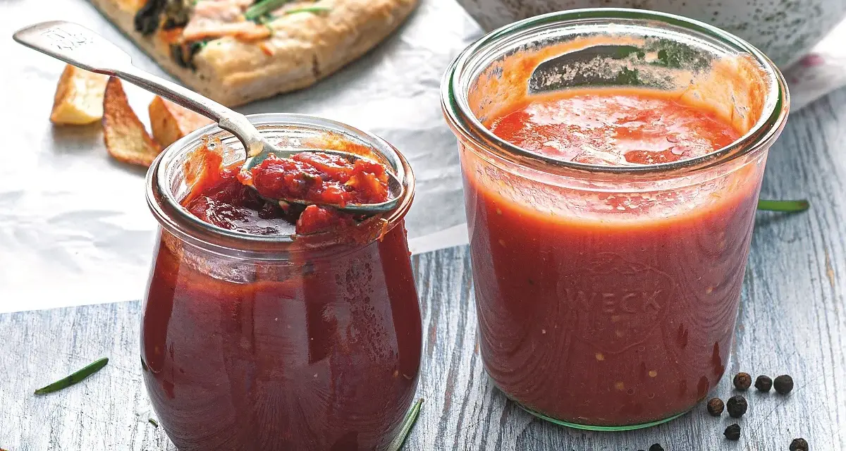 Dwa słoiczki Weck z domowymi dipami pomidorowymi, obok kawałek pizzy i miska makaronu. Idealne do pizzy i nie tylko!