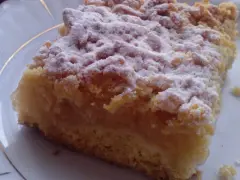 Kawałek puszystej szarlotki z kruszonką, posypanej cukrem pudrem. Idealna na podwieczorek, według najsmaczniejsza szarlotka przepis.