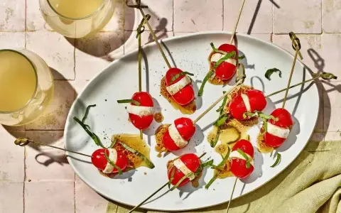 Proste przepisy na przekąski w 15 minut: szaszłyki caprese na chrupkim pieczywie z bazylią i sosem.