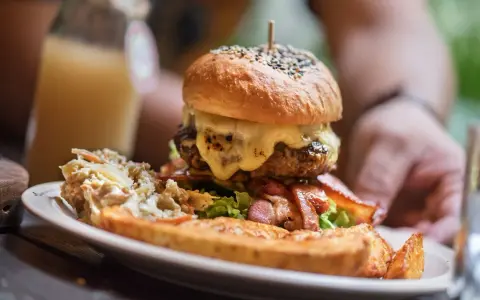 Pyszny burger drwala z rozpływającym się serem, chrupiącym boczkiem i surówką. Idealny na głód!