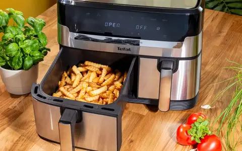 Frytki z frytkownicy beztłuszczowej Tefal, idealne do rankingu air fryer. Obok bazylia i pomidory.