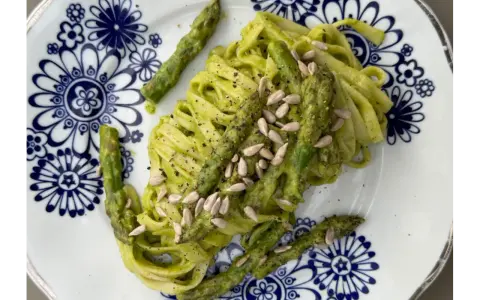 Makaron z zielonym pesto i szparagami, posypany pestkami słonecznika. Czy makaron jest zdrowy? Zależy od dodatków!