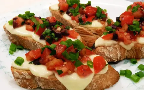 Bruschetta z pomidorami i mozzarellą: chrupiące pieczywo, roztopiony ser i świeże dodatki. Idealny przepis na szybką przekąskę.