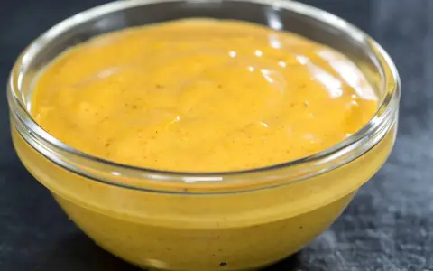 Gęsty, kremowy sos curry w szklanej miseczce, gotowy do podania z ulubionymi daniami.
